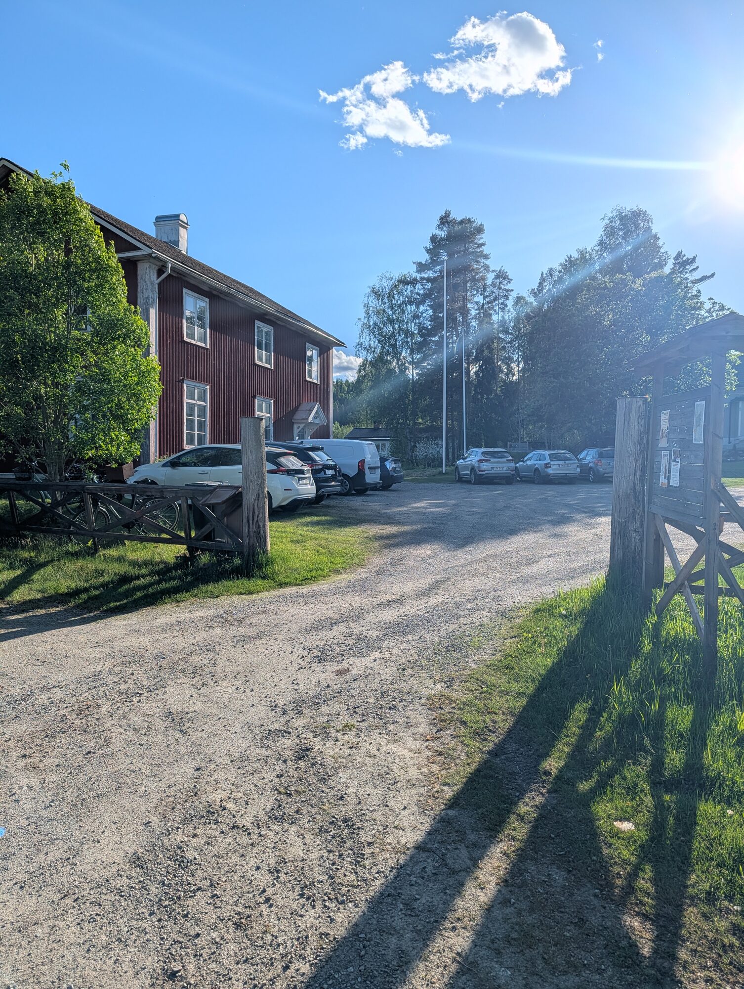 Skolan sedd från grusvägen i sommarkvällens ljus